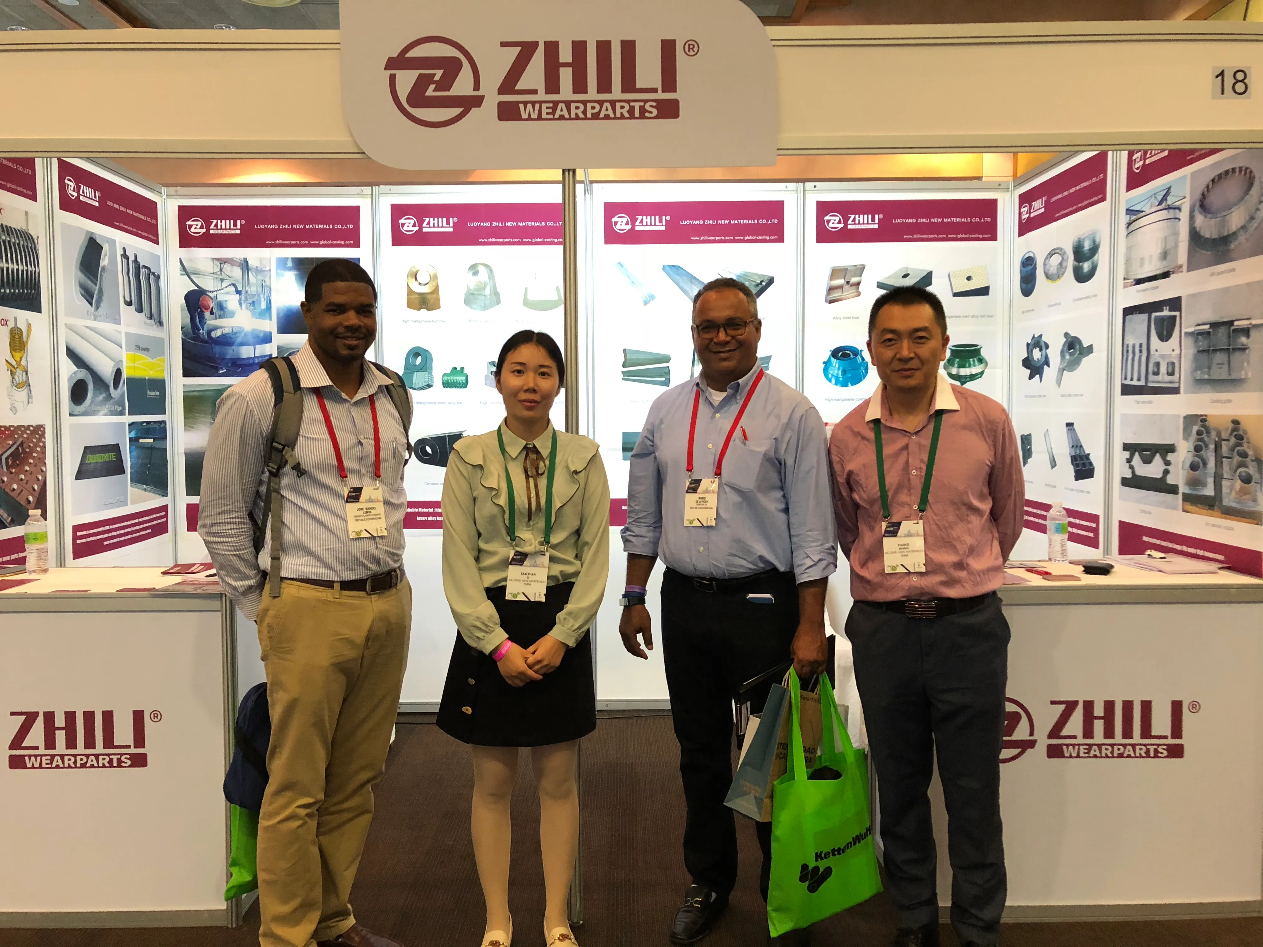 Representantes e visitantes diante de um estande anterior da ZL Wearparts